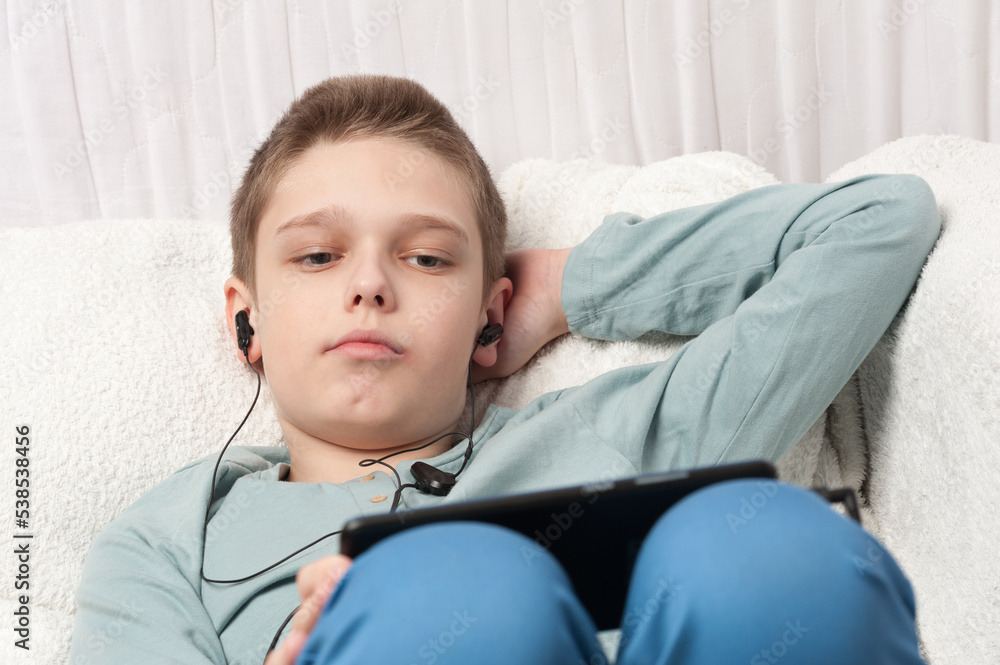 The boy learning online using tablet and earphones The boy learning online using tablet and earphones