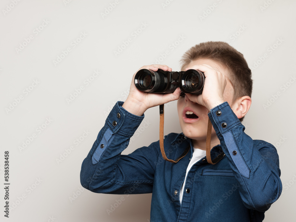 The boy makes observations looking through binoculars The boy makes observations looking through binoculars