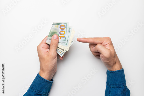businessman holding a stack of euro banknotes in his hand, points his finger at money, income, success