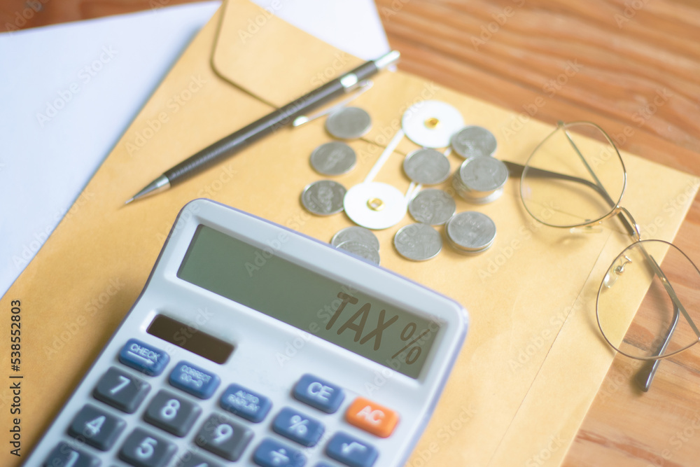 Word Tax 2023 on the calculator business ideas and taxes Calculator, currency, books, tax forms and vanta pen on wooden table Word Tax 2023 on the calculator business ideas and taxes Calculator, currency, books, tax forms and vanta pen on wooden table