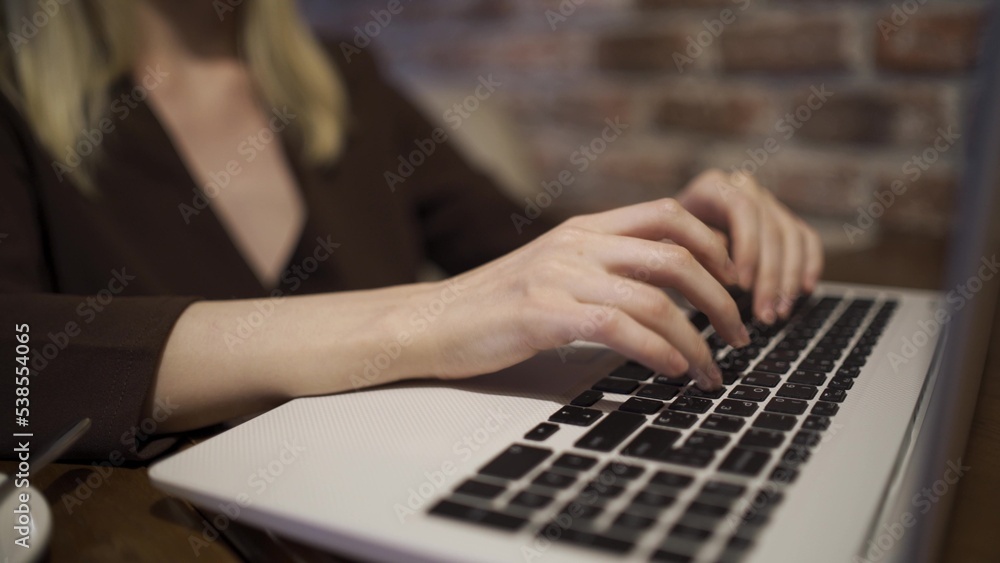 A woman is typing on a laptop keyboard close-up. Female hands and laptop. A woman is typing on a laptop keyboard close-up. Female hands and laptop.