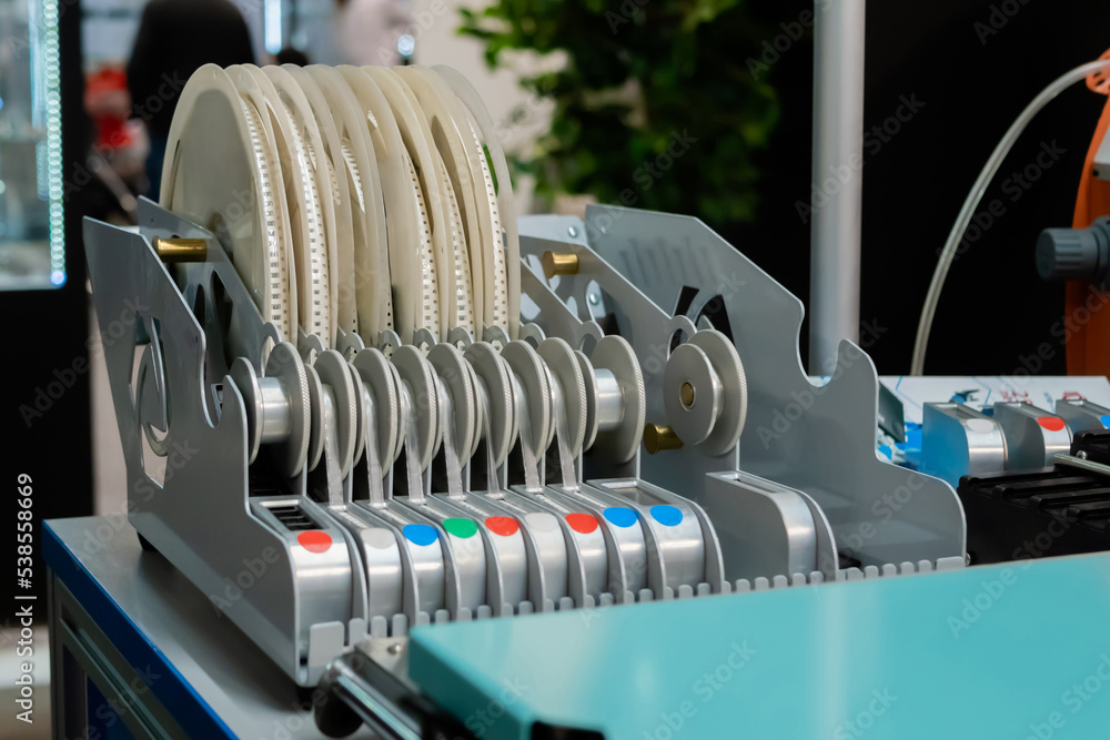 Reels with different electronic components, part of pick and place machine. Technology, industrial, production and manufacturing concept Reels with different electronic components, part of pick and place machine. Technology, industrial, production and manufacturing concept