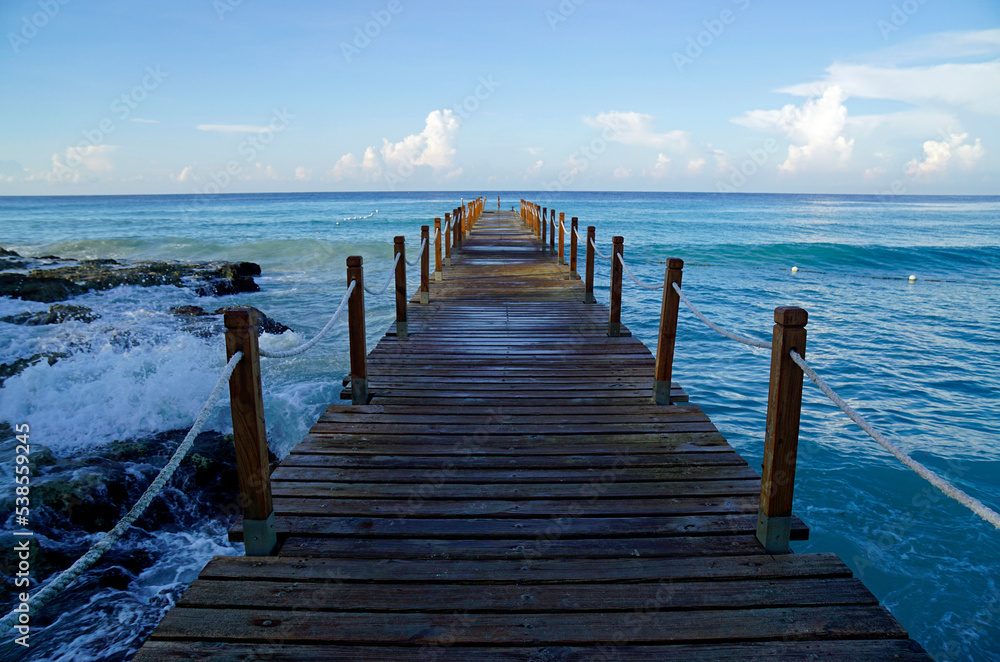 wooden jetty at a caribbean beach in the morning