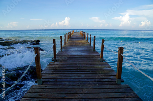 wooden jetty at a caribbean beach in the morning