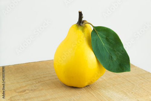 Owoc pigwy z zielonym liściem na desce