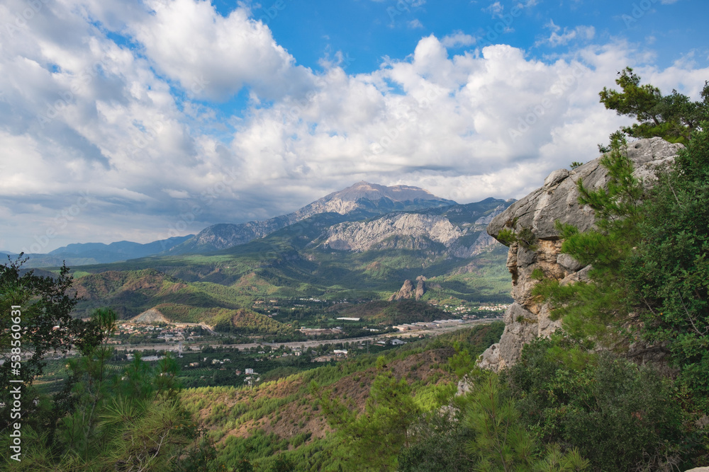 Beautiful mountain landscape. Rocks with pine trees and rocks in the foreground and a blue sky with white clouds in the background. Beautiful mountain landscape. Rocks with pine trees and rocks in the foreground and a blue sky with white clouds in the background.