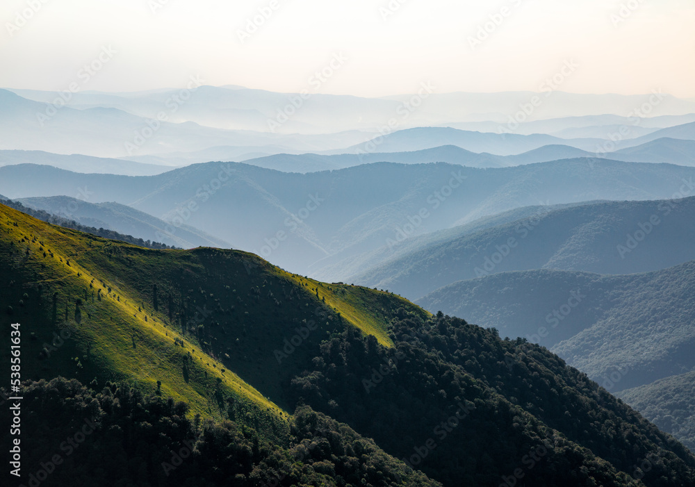 Spring morning. Landscape with high mountains and green forest. Panoramic view. Scenery of village. The meadow with green grass. Wallpaper background. Touristic place Carpathian park.