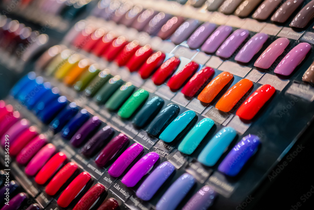 Set of multicolored palletes of gel nail polishes on counter of cosmetic store, manicure salon, exhibition - close up view. Fashion, care, cosmetic, beauty, glamour concept Set of multicolored palletes of gel nail polishes on counter of cosmetic store, manicure salon, exhibition - close up view. Fashion, care, cosmetic, beauty, glamour concept
