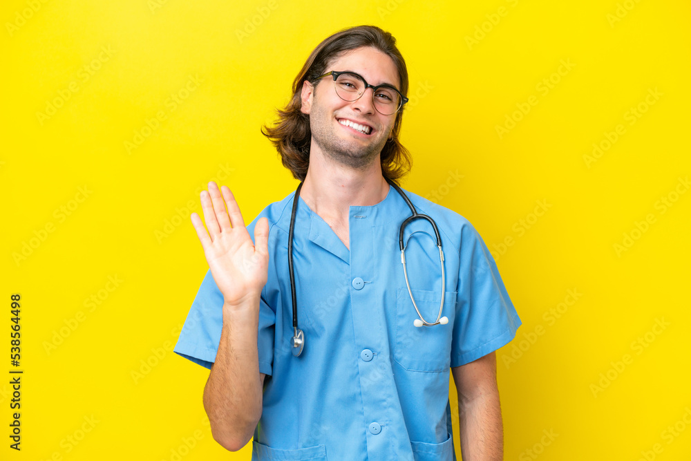 Young surgeon caucasian man isolated on yellow background saluting with hand with happy expression Young surgeon caucasian man isolated on yellow background saluting with hand with happy expression