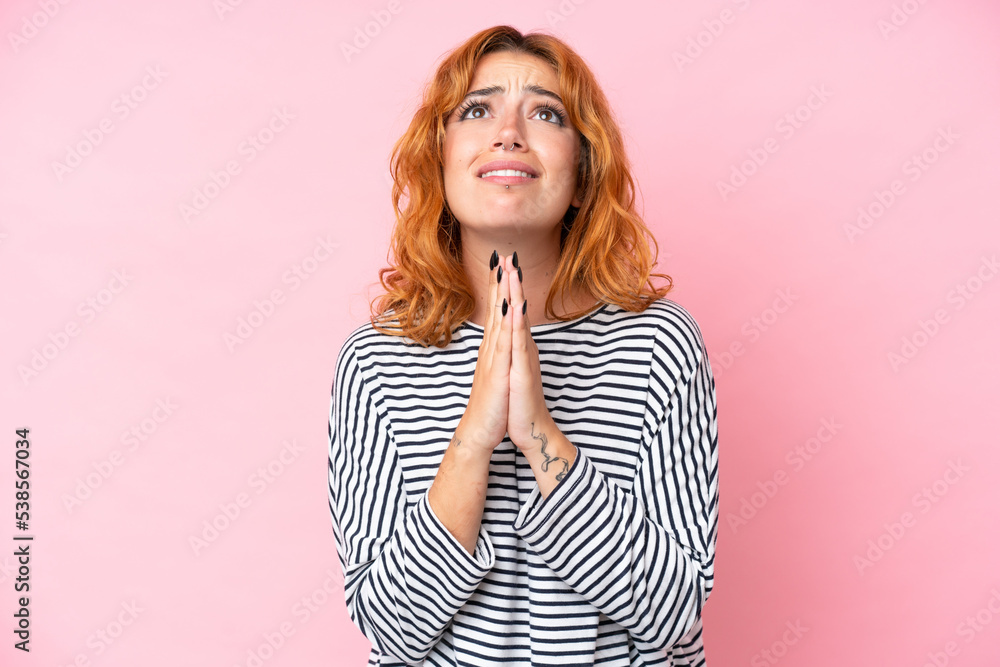 Young caucasian woman isolated on pink background keeps palm together. Person asks for something Young caucasian woman isolated on pink background keeps palm together. Person asks for something