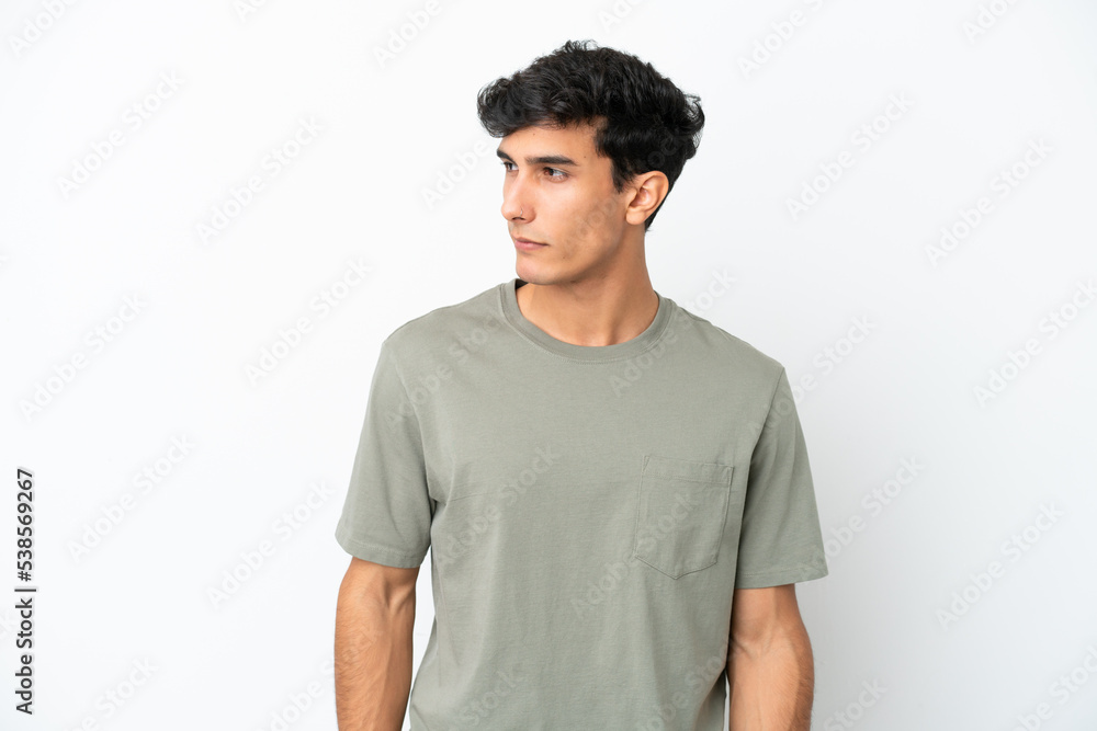 Young Argentinian man isolated on white background looking to the side Young Argentinian man isolated on white background looking to the side