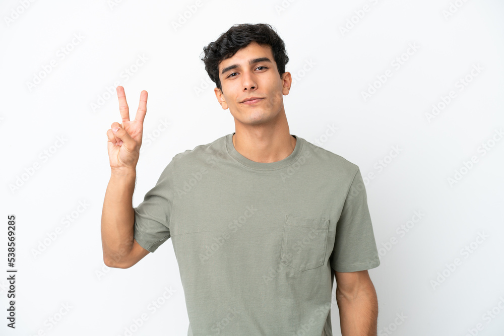 Young Argentinian man isolated on white background smiling and showing victory sign Young Argentinian man isolated on white background smiling and showing victory sign