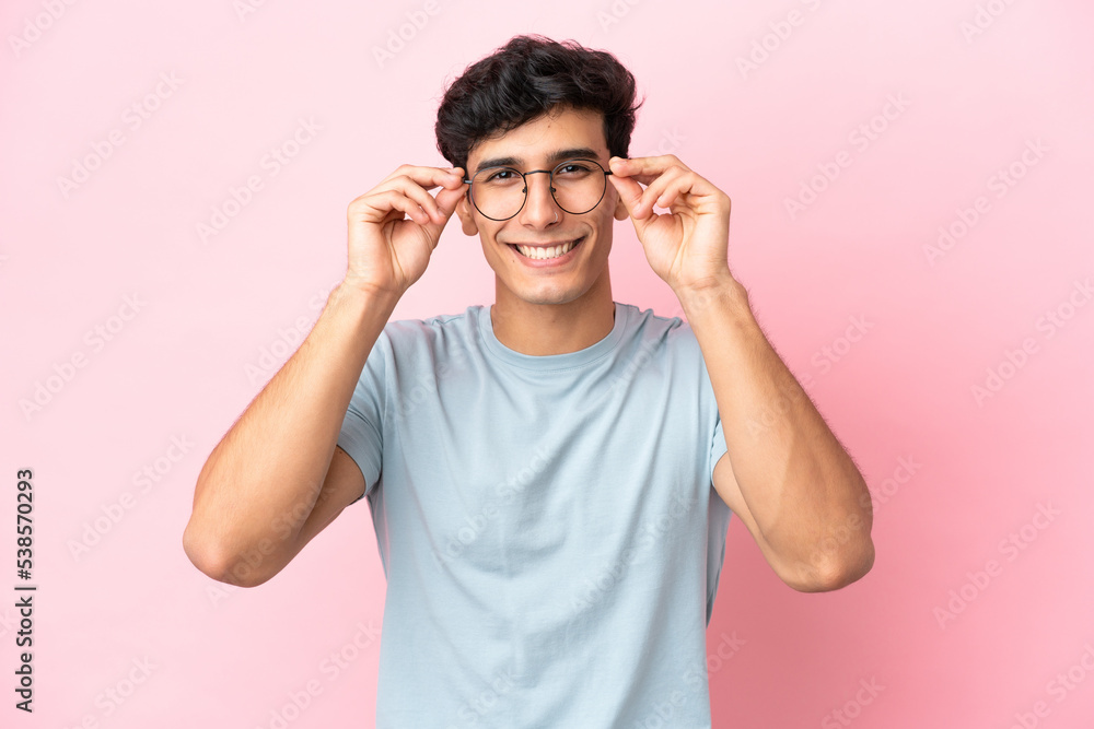 Young Argentinian man isolated on pink background With glasses with happy expression Young Argentinian man isolated on pink background With glasses with happy expression