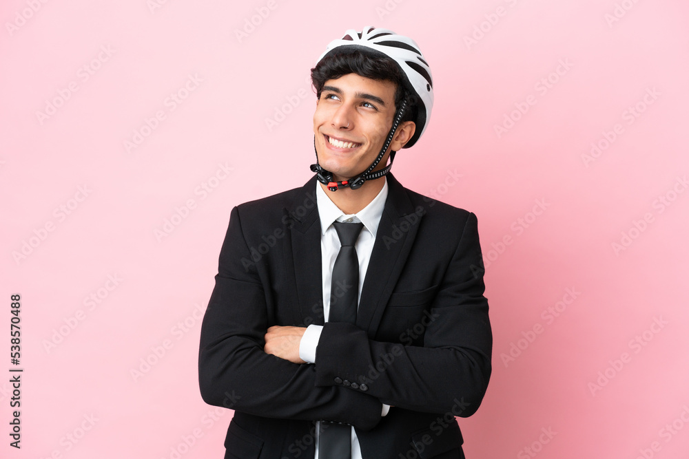 Argentinian businessman with bike helmen isoleted on pink background Argentinian businessman with bike helmen isoleted on pink background