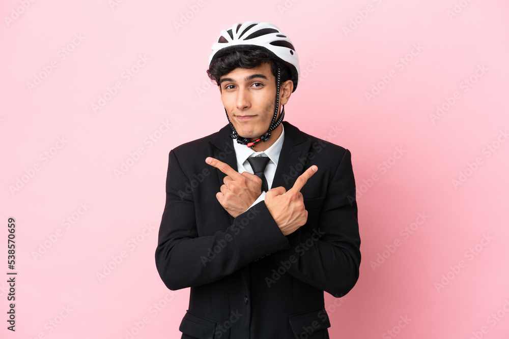 Argentinian businessman with bike helmen isoleted on pink background Argentinian businessman with bike helmen isoleted on pink background
