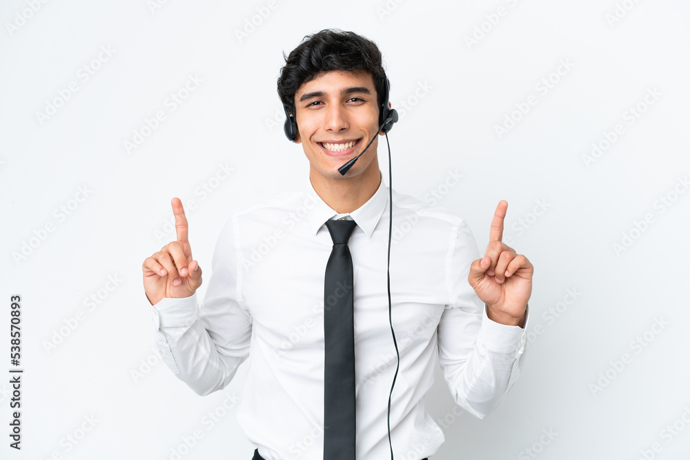 Telemarketer man working with a headset isolated on white background pointing up a great idea