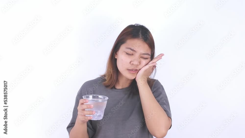 Asian woman has tooth sensitivity after drinking cold water, tooth decay, health concept Asian woman has tooth sensitivity after drinking cold water, tooth decay, health concept