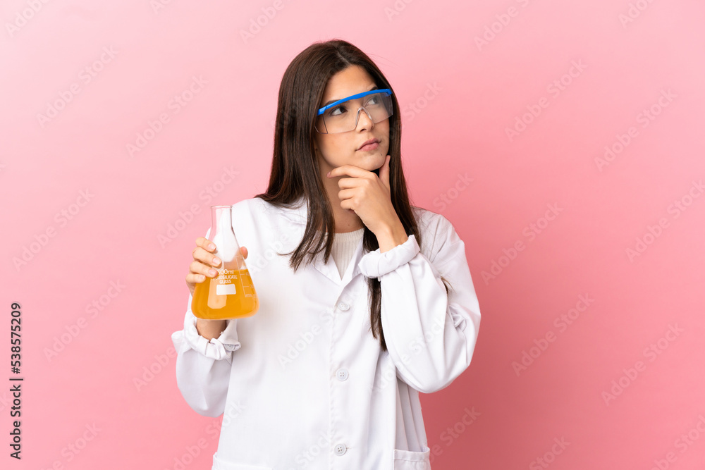 Young scientific girl over isolated pink background having doubts Young scientific girl over isolated pink background having doubts