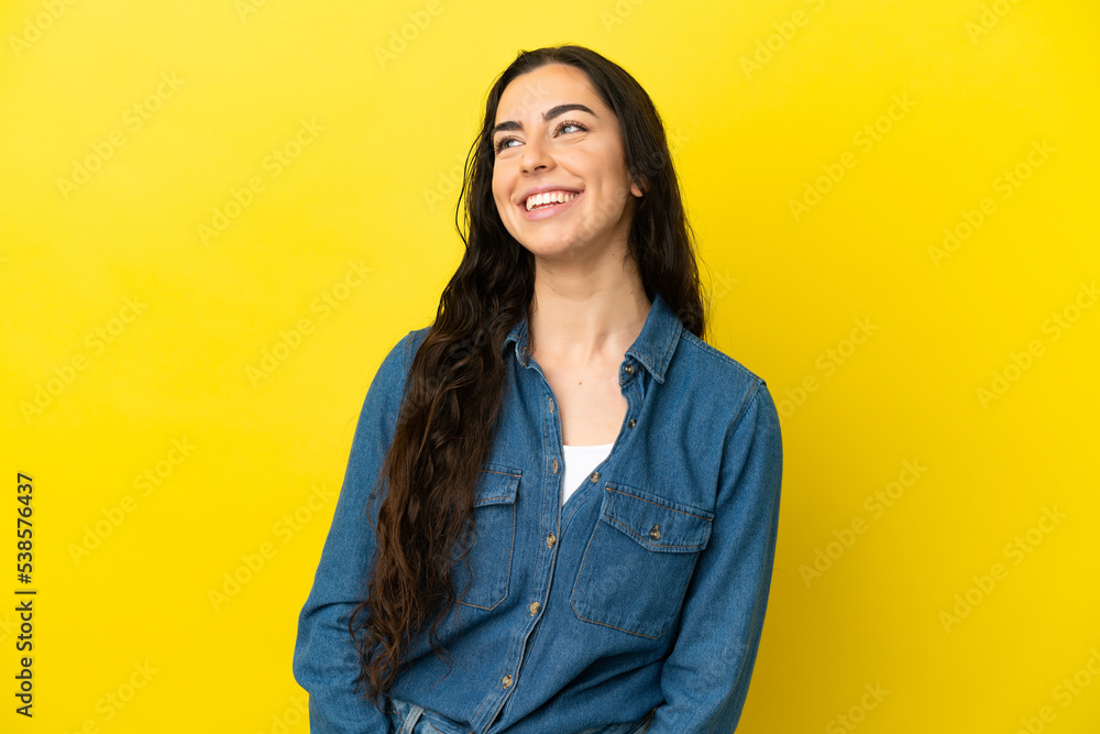Young caucasian woman isolated on yellow background thinking an idea while looking up Young caucasian woman isolated on yellow background thinking an idea while looking up