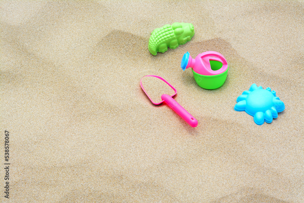 Set of colorful beach toys on sand. Space for text Set of colorful beach toys on sand. Space for text