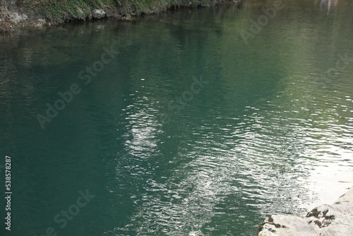 Picturesque view of clean pond near stones outdoors