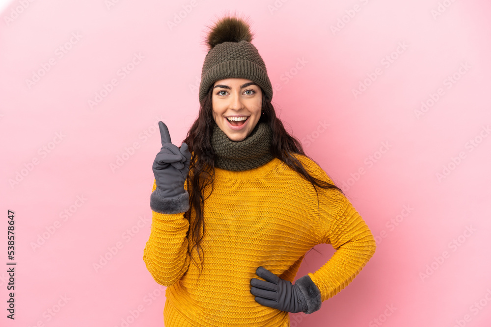 Young caucasian girl with winter hat isolated on purple background thinking an idea pointing the finger up Young caucasian girl with winter hat isolated on purple background thinking an idea pointing the finger up