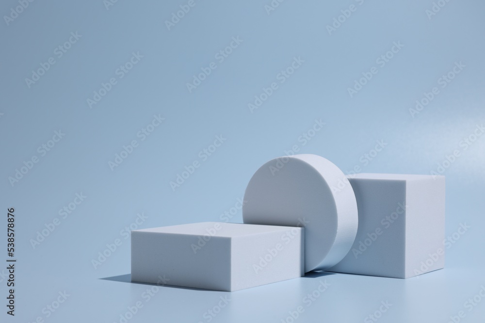 Scene for product presentation. Podiums of different geometric shapes on light blue background Scene for product presentation. Podiums of different geometric shapes on light blue background
