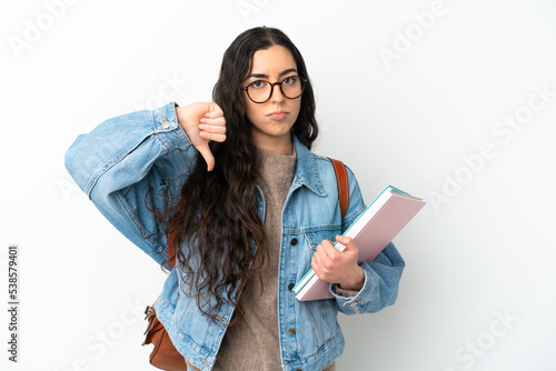 Young student woman isolated on white background showing thumb down with negative expression