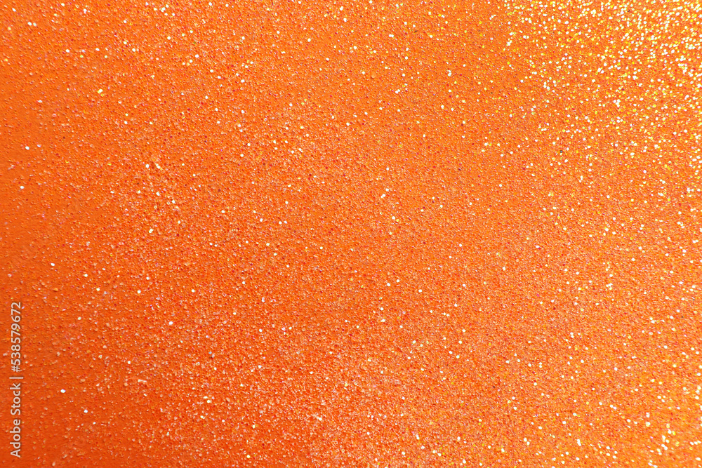 Shiny bright glitter on orange background, flat lay Shiny bright glitter on orange background, flat lay