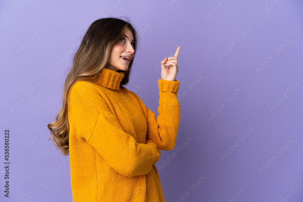 Young caucasian woman isolated on purple background pointing up a great idea Young caucasian woman isolated on purple background pointing up a great idea