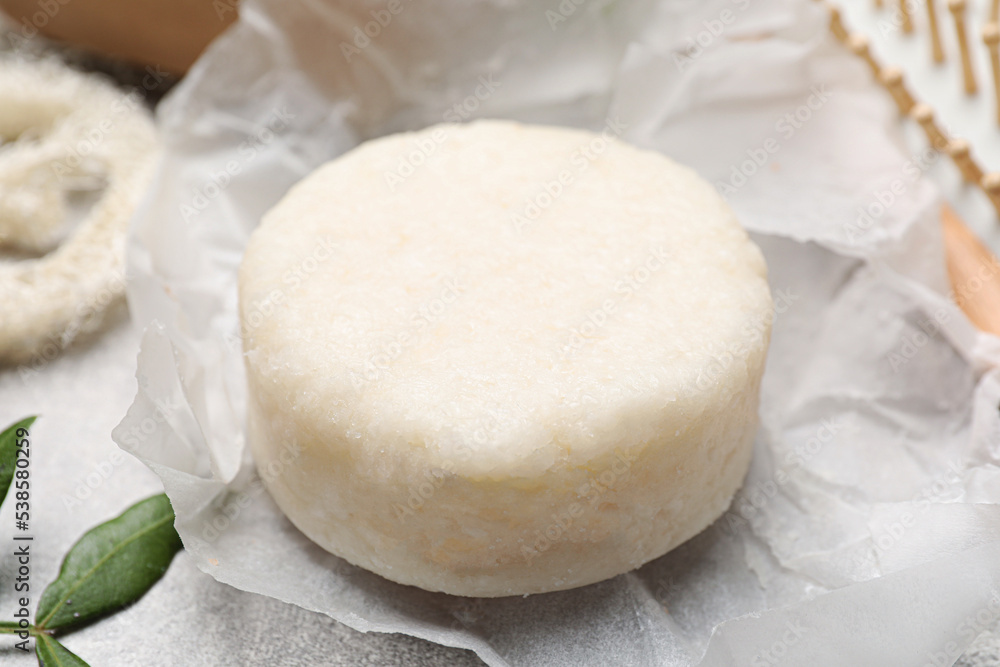 Solid shampoo bar on light grey table, closeup Solid shampoo bar on light grey table, closeup