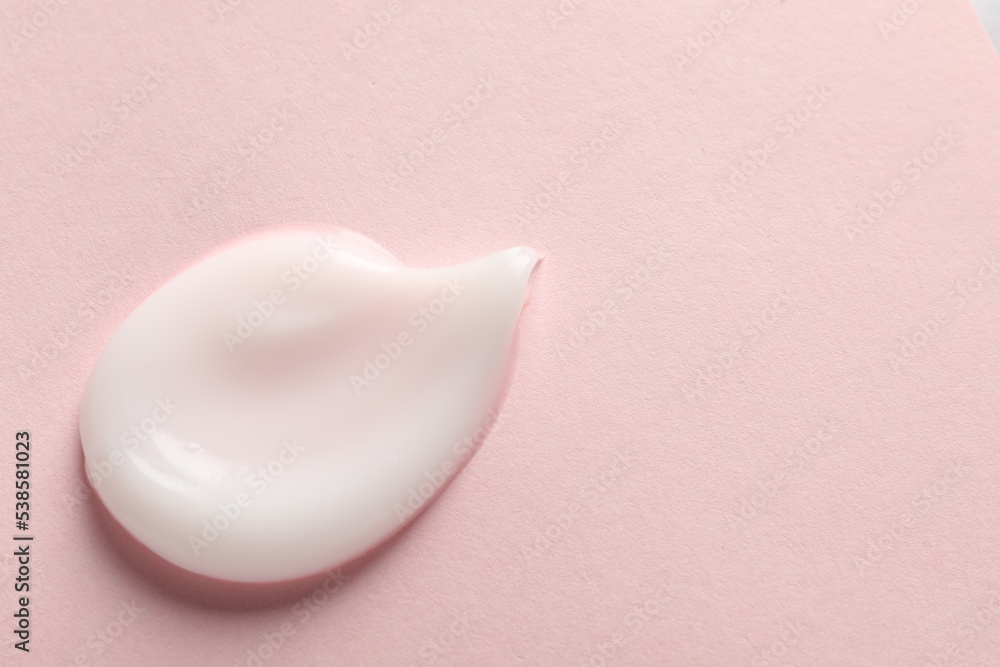 Sample of face cream on pink background, top view. Space for text