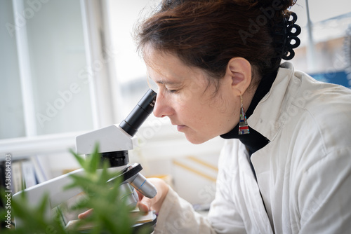 Chercheuse regardant dans un microscope dans son laboratoire de recherche photo