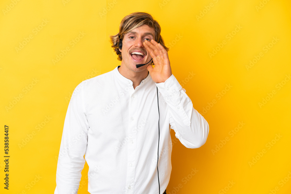 Telemarketer man working with a headset isolated on yellow background shouting with mouth wide open Telemarketer man working with a headset isolated on yellow background shouting with mouth wide open