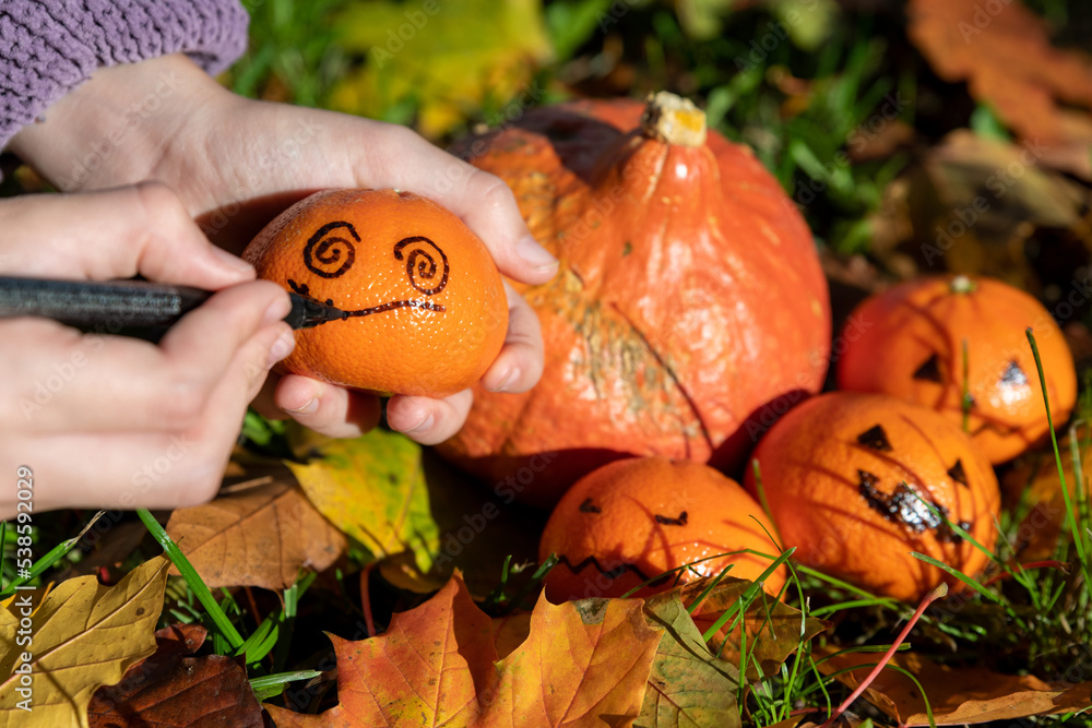 Kindliche Hände basteln Halloween Deko im herbstlichen Garten mit