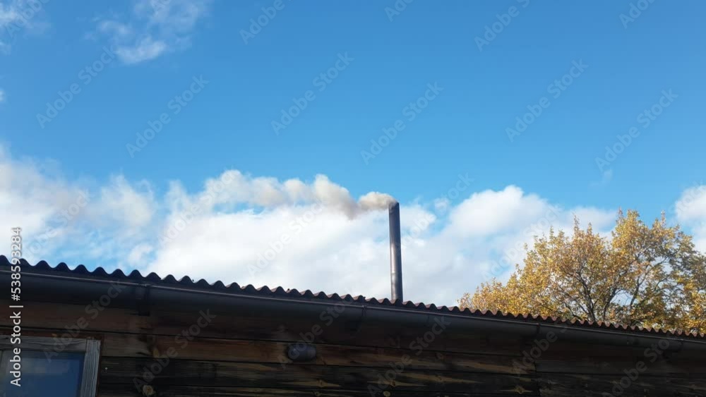 smoke from a chimney against the sky, heating of a cottage with coal, environmental pollution and energy crisis. smoke from a chimney against the sky, heating of a cottage with coal, environmental pollution and energy crisis.