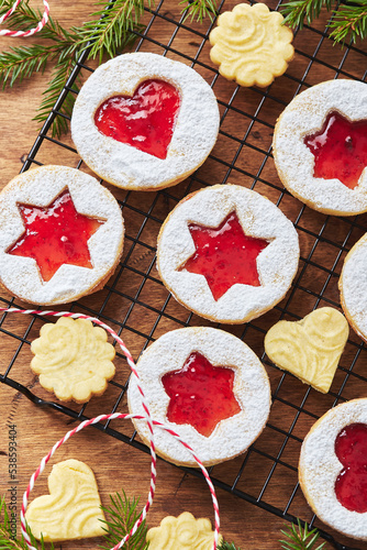 Classic Linzer Christmas Cookies with raspberry or strawberry jam on wooden table photo