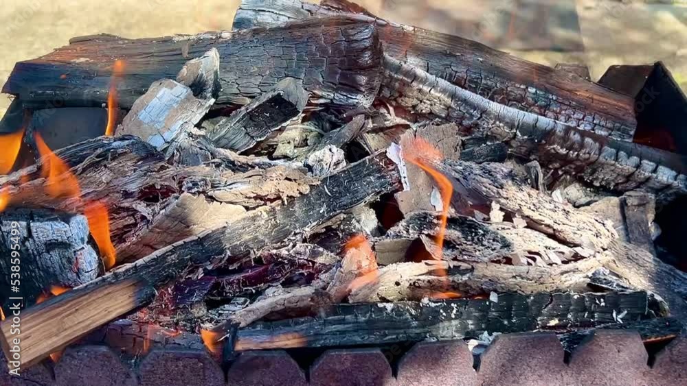 Metal mangal with coals. Flame of fire from burning charcoal log in the bonfire on the bbq grill. Metal mangal with coals. Flame of fire from burning charcoal log in the bonfire on the bbq grill.