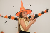 portrait of a happy girl in halloween costumes at home, communicating using a smartphone with friends and relatives, online congratulations on the phone with halloween