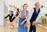 Man and woman performing jazz dance in dancing room