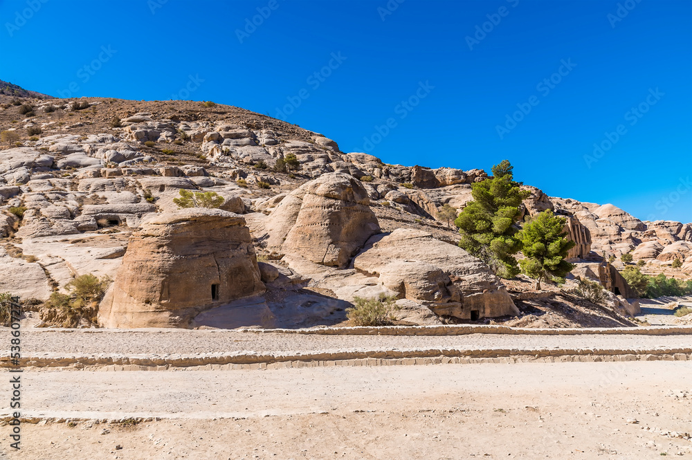 A view of old dwellings beside the path leading to the ancient city of Petra, Jordan in summertime