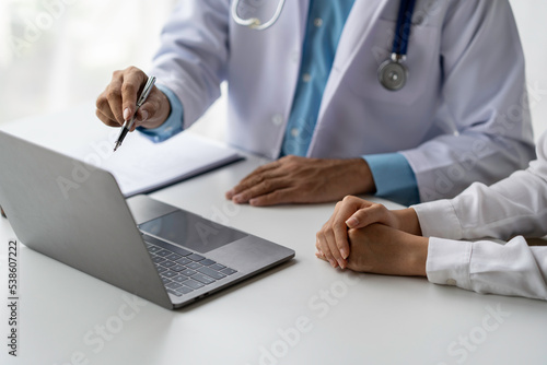 The male doctor explained in detail. Treatment methods and body feedback on a laptop for the patient to see.