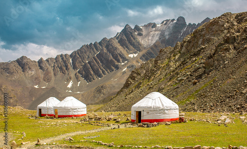 Yurt. National old house of the peoples of Kyrgyzstan and Asian countries. national housing. Yurts on the background of green meadows and highlands. Yurt camp for tourists. photo