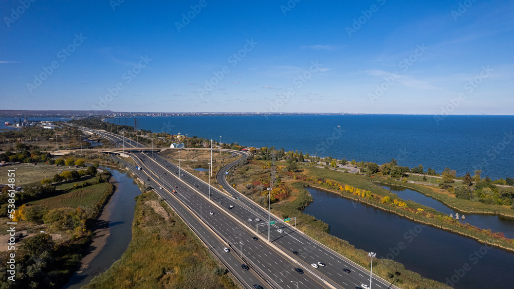 Aerial view of the blue sea, lakes and a busy highway under the clear blue sky Aerial view of the blue sea, lakes and a busy highway under the clear blue sky