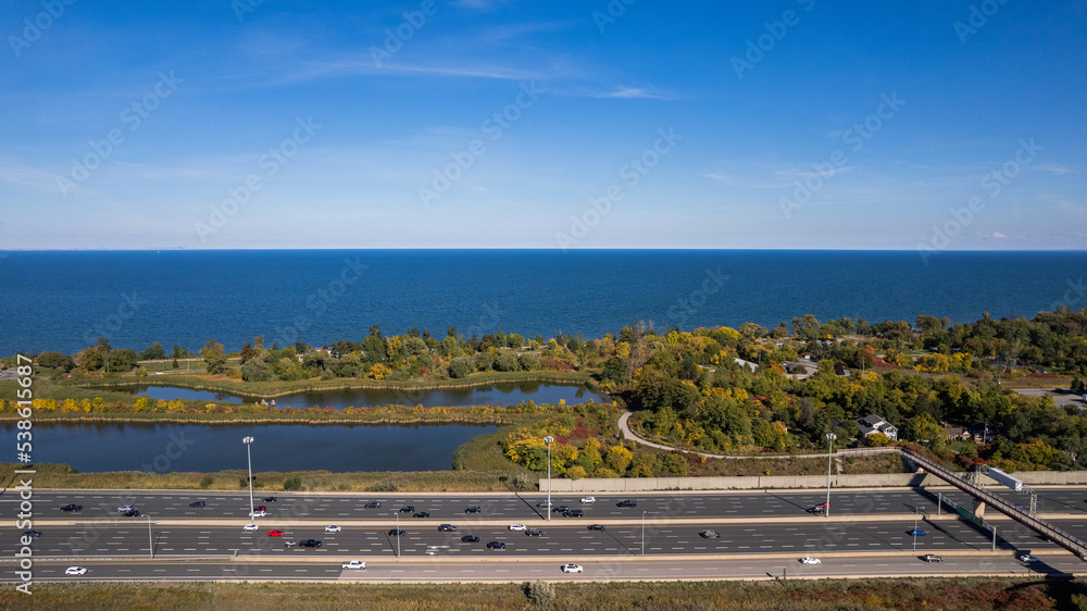 Aerial view of the blue sea, lakes and a busy highway under the clear blue sky Aerial view of the blue sea, lakes and a busy highway under the clear blue sky