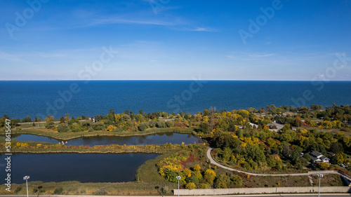 Aerial view of the blue sea and lakes with coastline trees and buildings under the blue sky