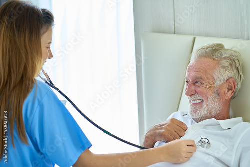 A nurse checks the patient's health at home with a stethoscope. photo