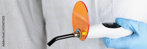 Fototapete The doctor is holding dental led curing light, close-up