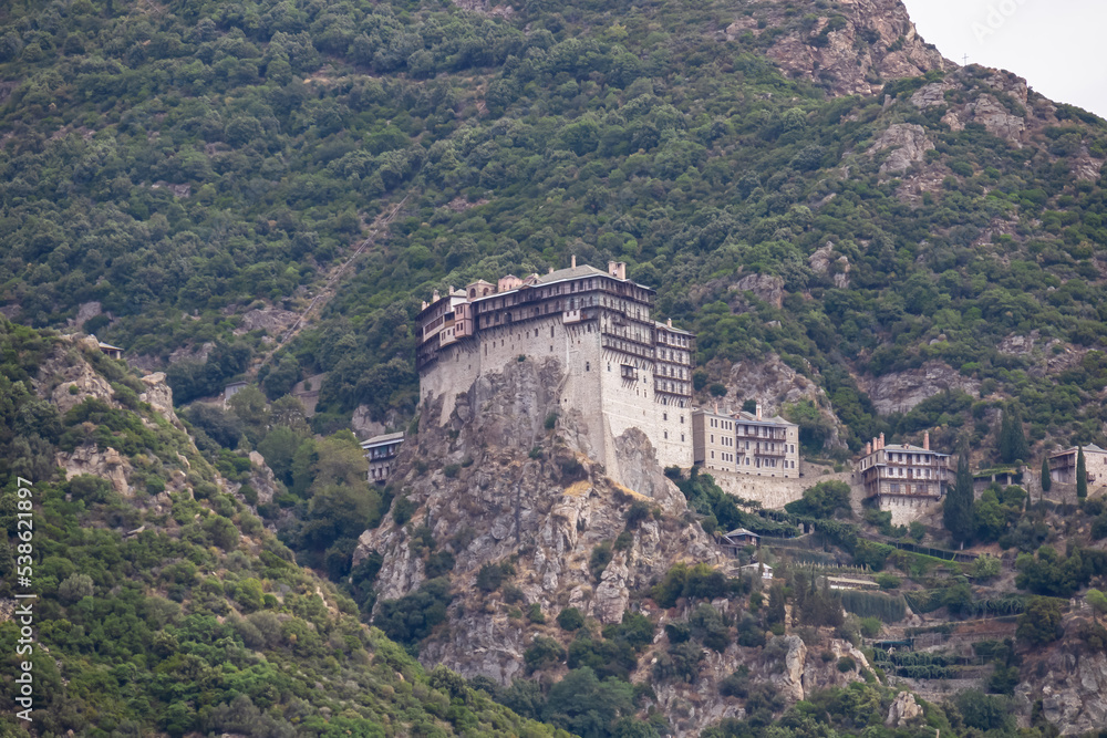 Fototapeta premium Scenic view from boat on Simonopetra Monastery (Simonos Petra) at Mount Athos, Chalkidiki, Central Macedonia, Greece, Europe. Eastern Orthodox terrain of Again Oros. Landmark build on rock formation