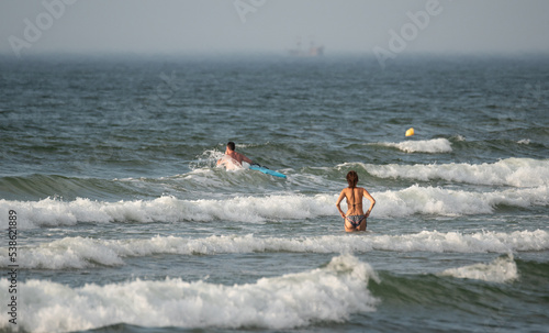 Rough sea. People on the waves at sea. Swimming in the sea with big waves. Dangerous conditions in the water. © PhotoRK